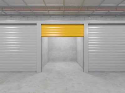 Front View Of Self Storage Units With Roller Doors. Empty Open Unit With Yellow Door
